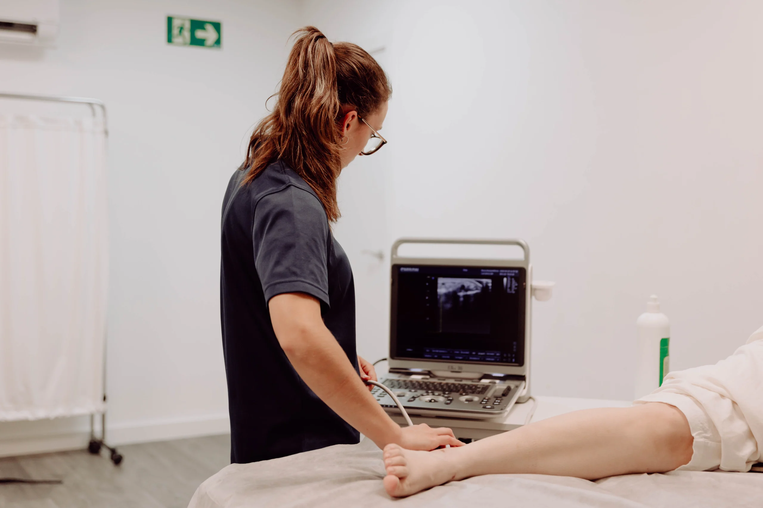 Fisioterapeuta realizando exploración ecográfica musculoesquelética en Clínica Axon Valencia
